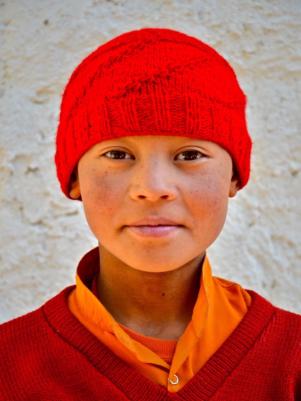 Portrait image of a child in a red hat and jacket