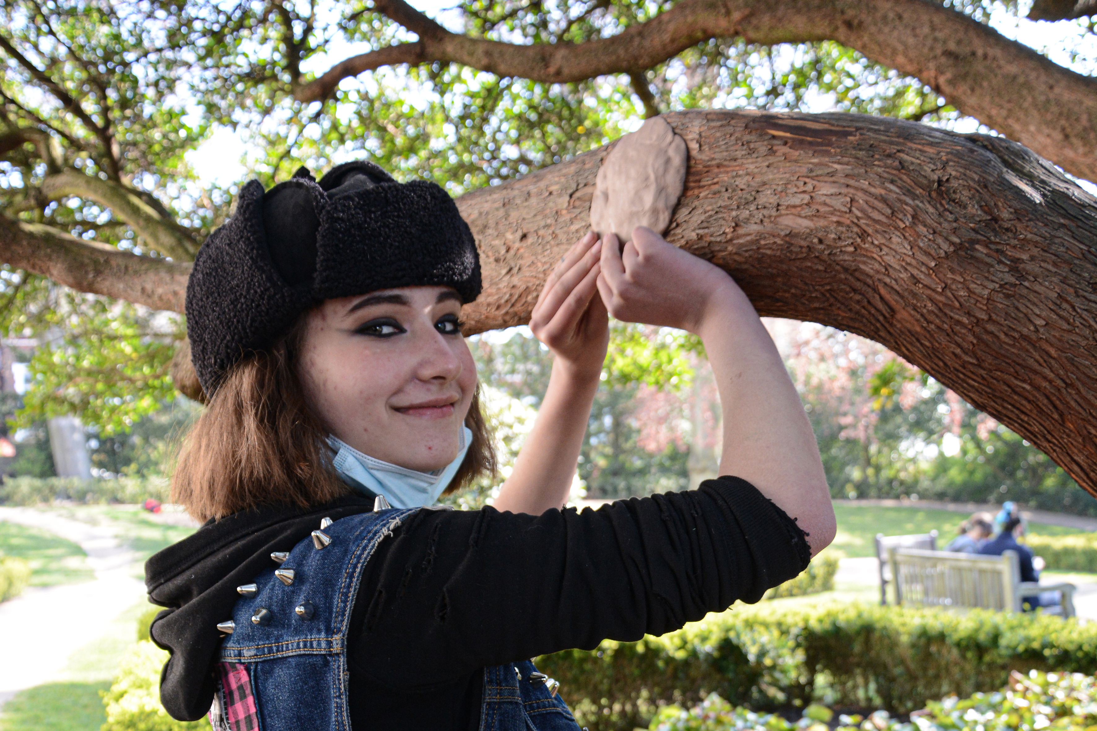 Student hanging their work in a tree