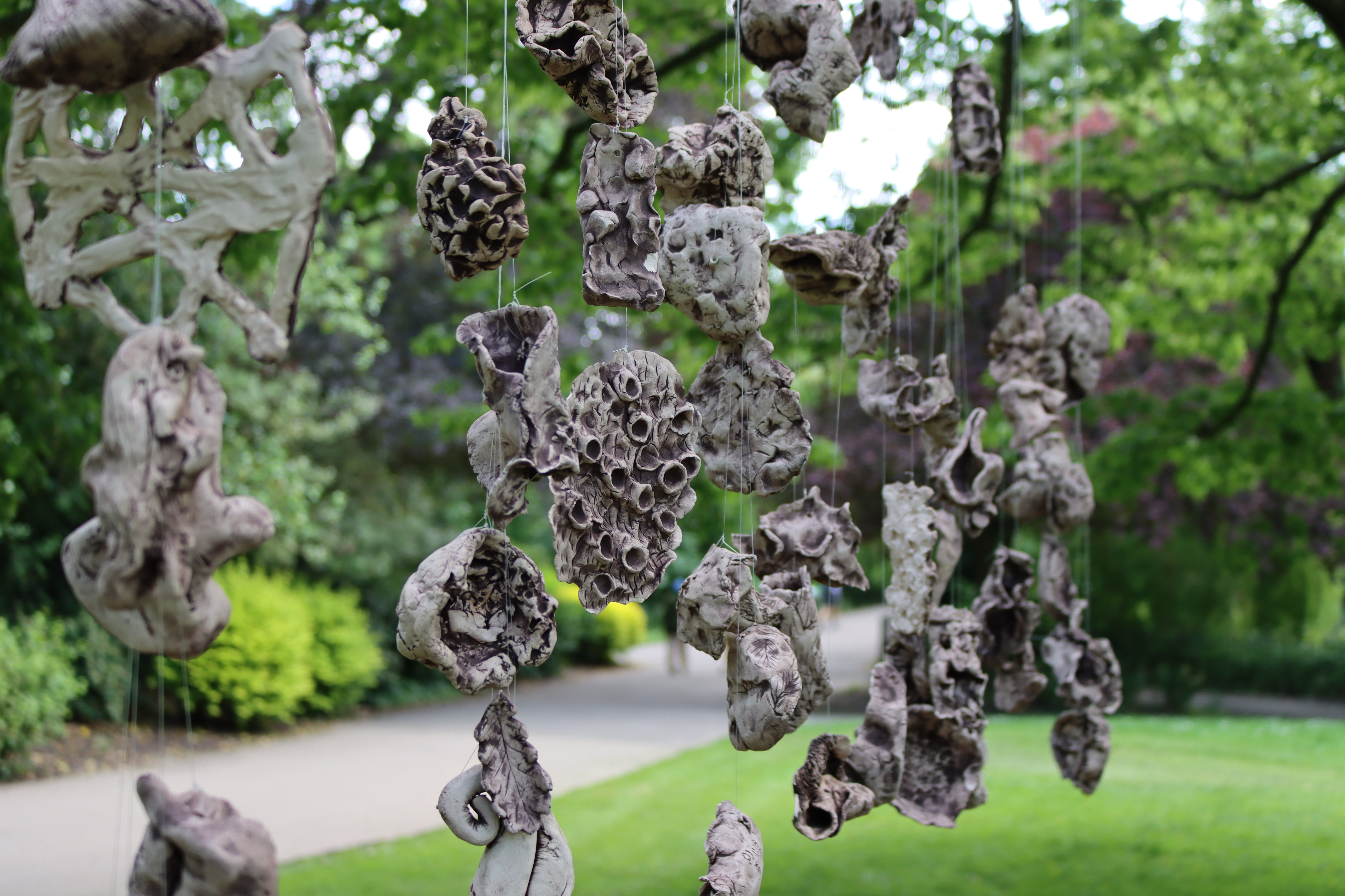 Clay artwork hanging from a tree in Waterlow Park