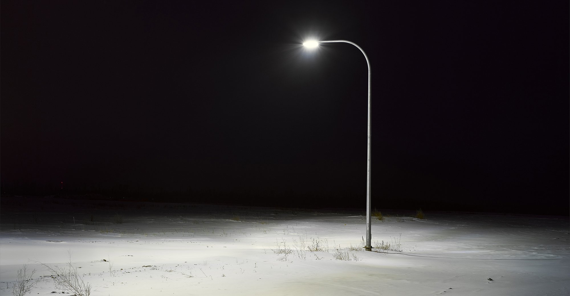 Photograph of a lone street lamp in the dark