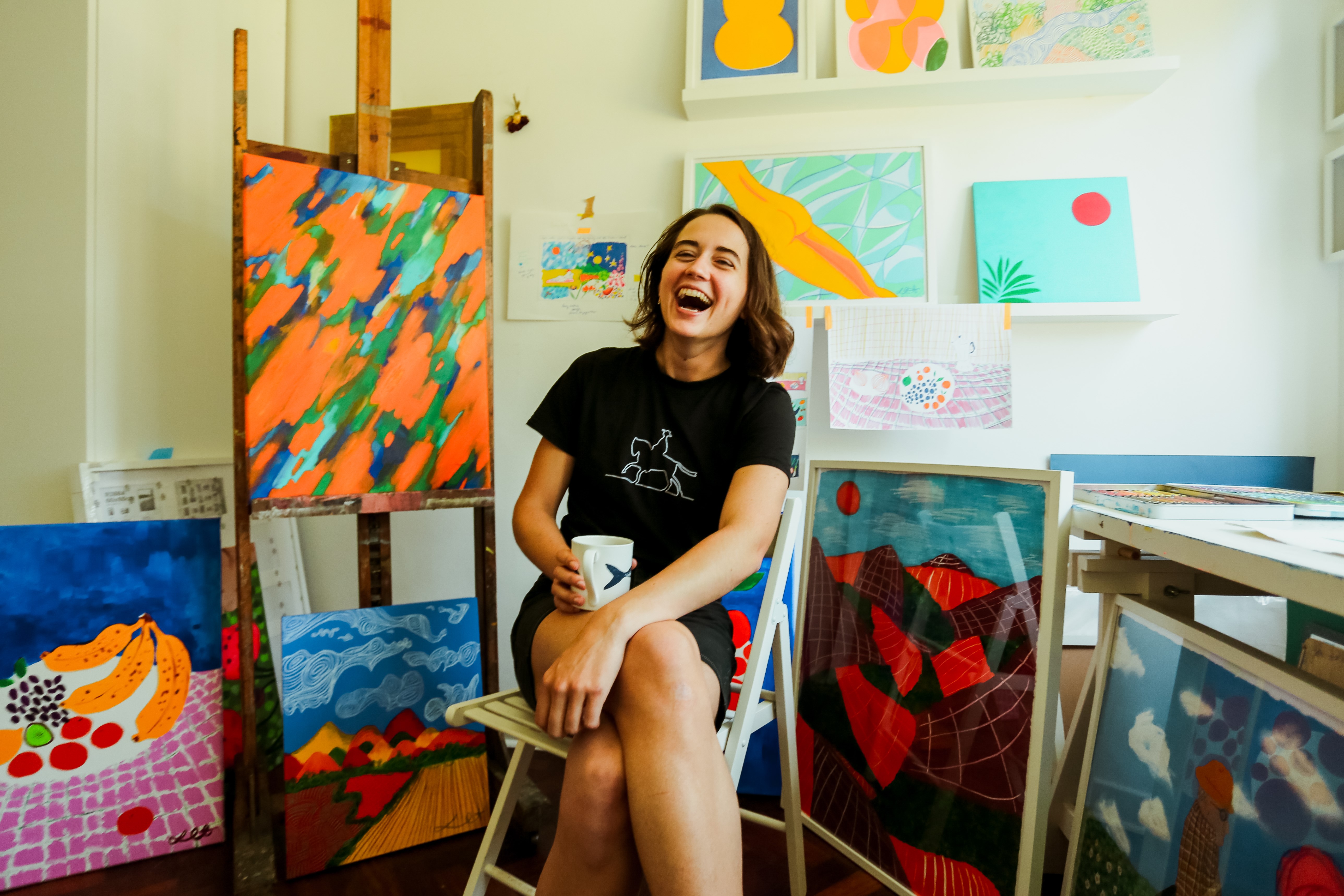 Photograph of Lily Rose Grant and her paintings by Alex Krook