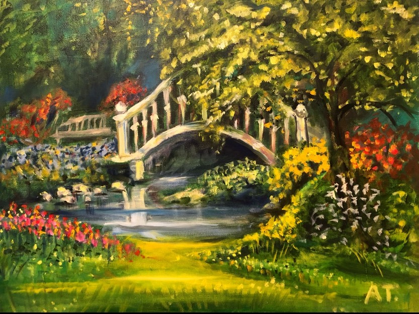 An arched bridge over water surrounded by flowers