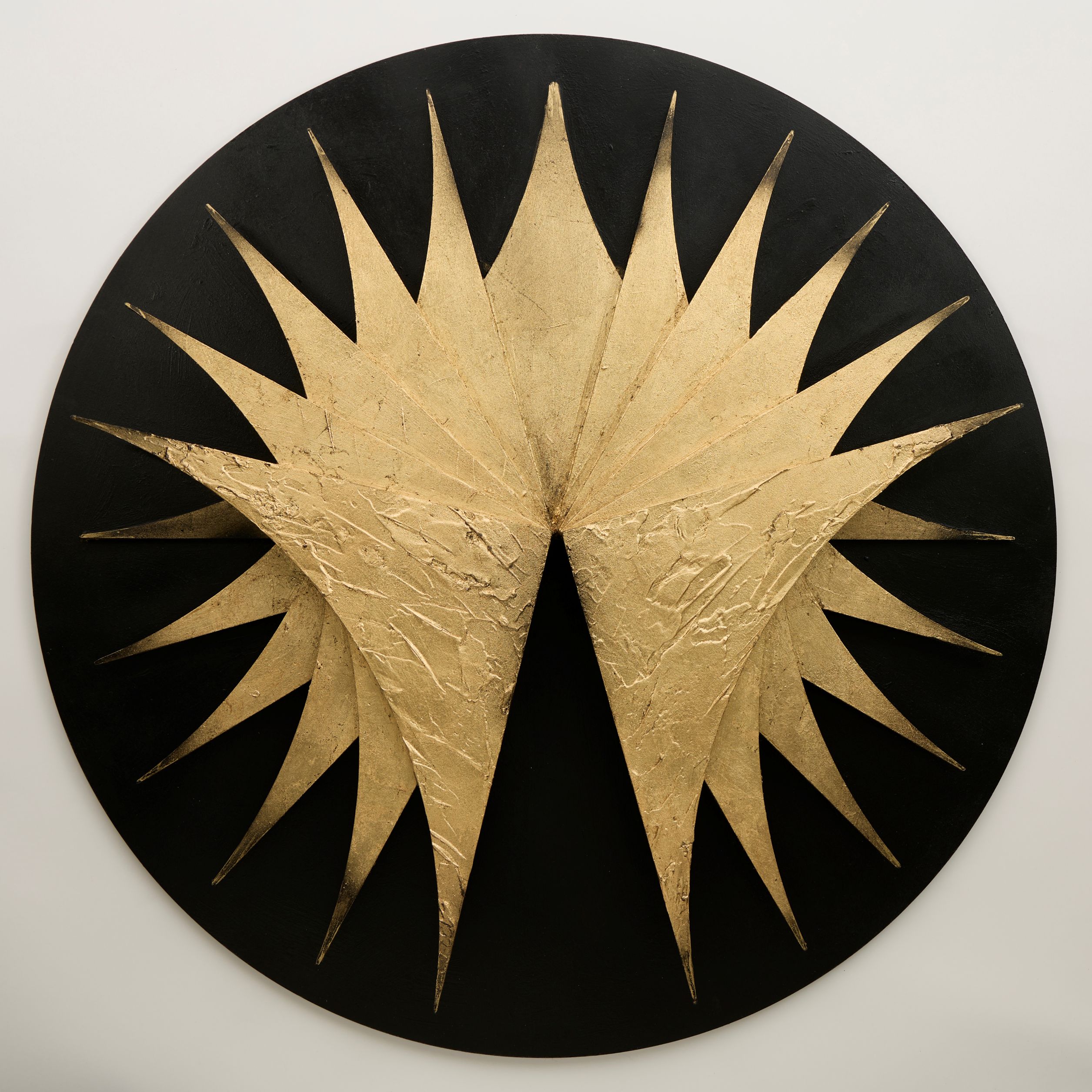 Black circular artwork with golden sun-like feature in the centre
