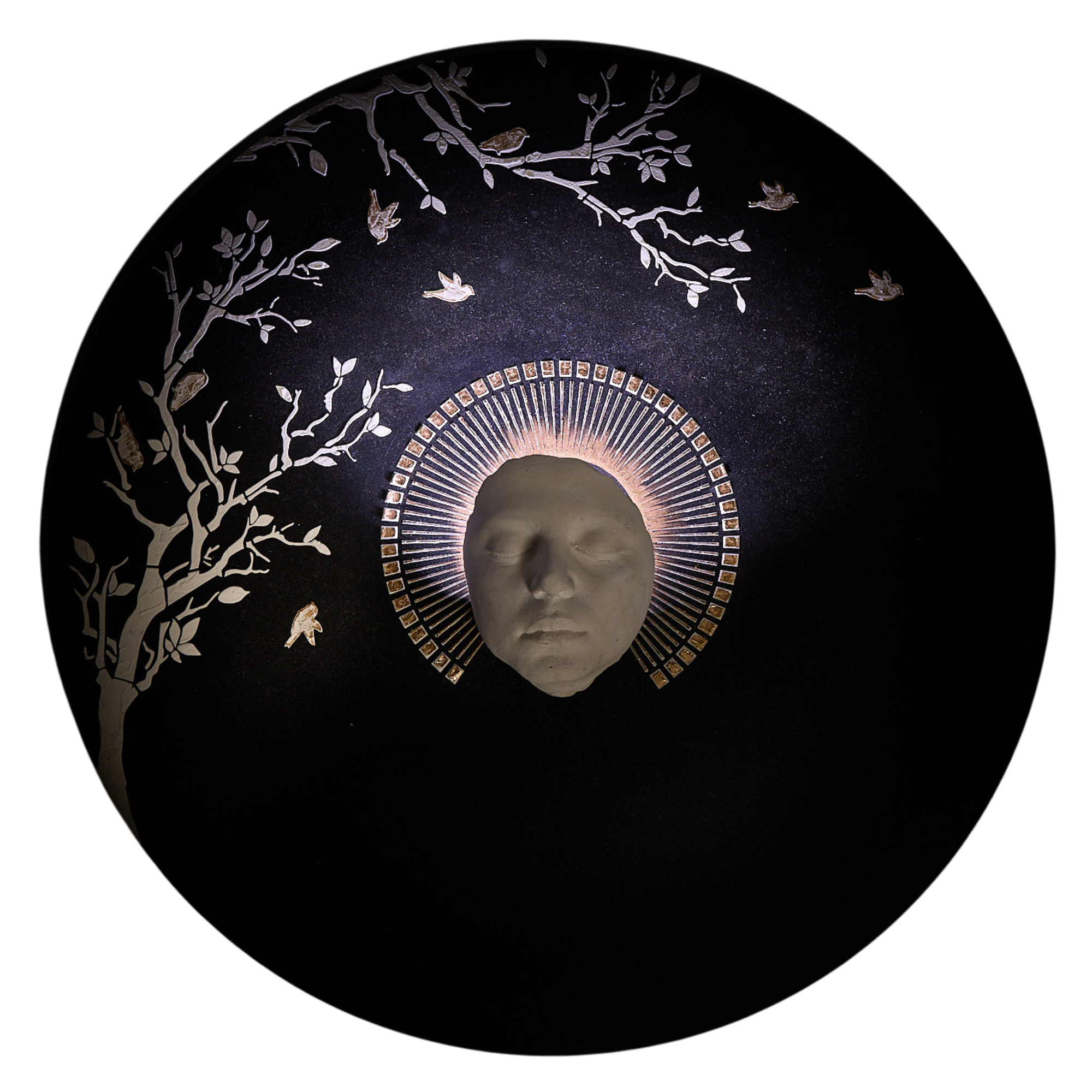 Black circular art piece with face in the centre and tree branches in the top left corner.