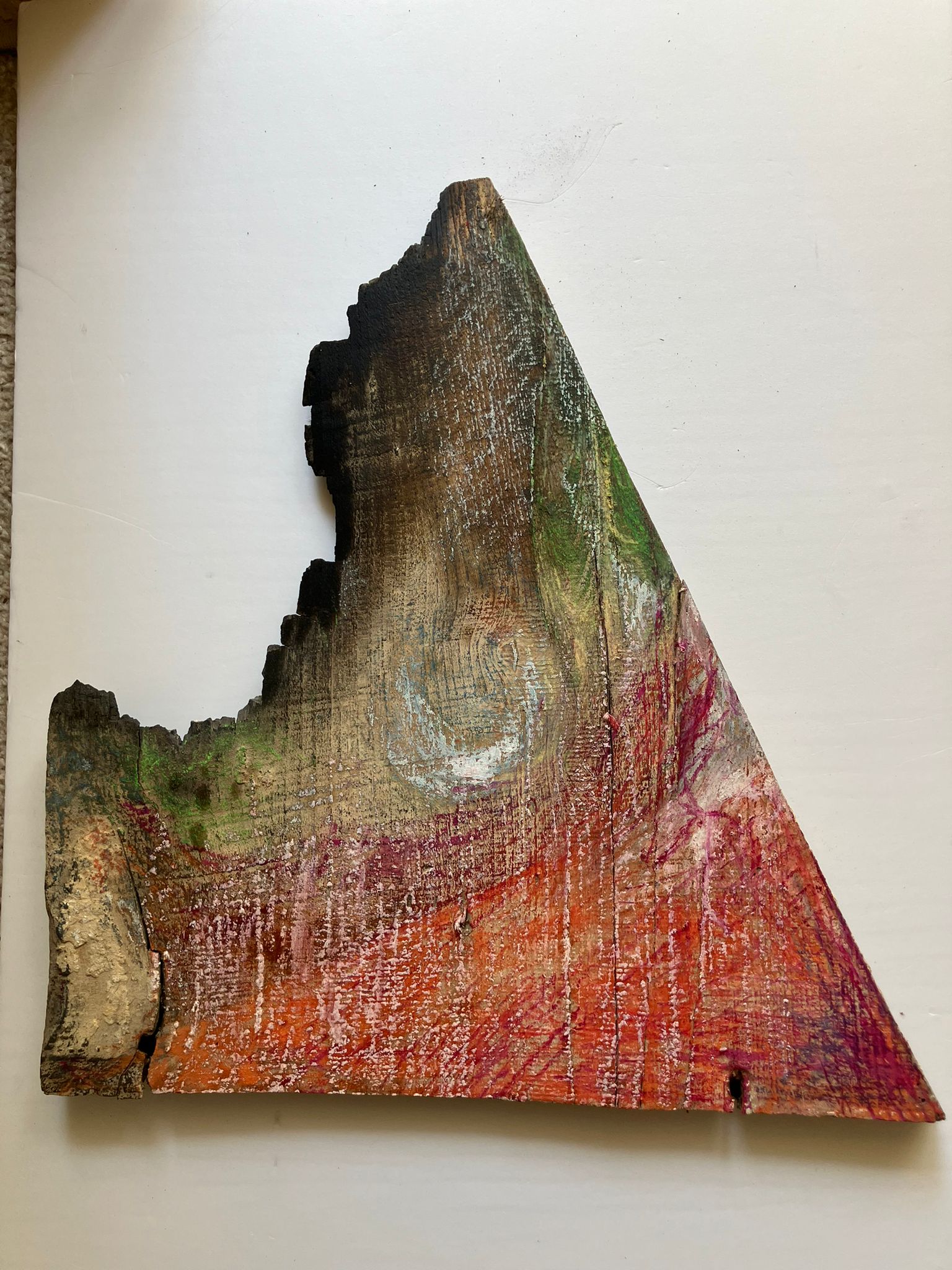 Wood plank in a triangle shape with green and red paint