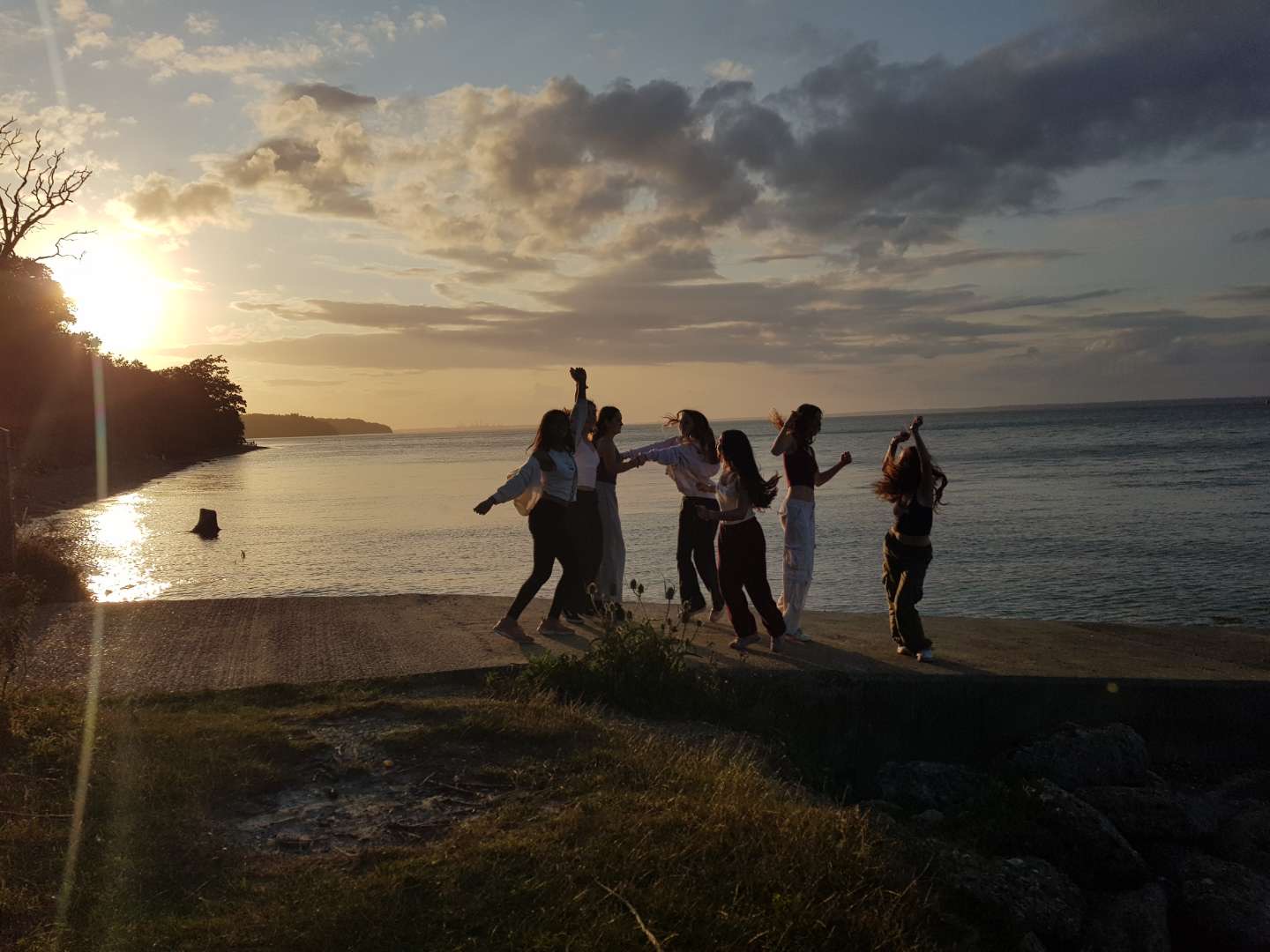 Young girls dancing on a beach at sunset