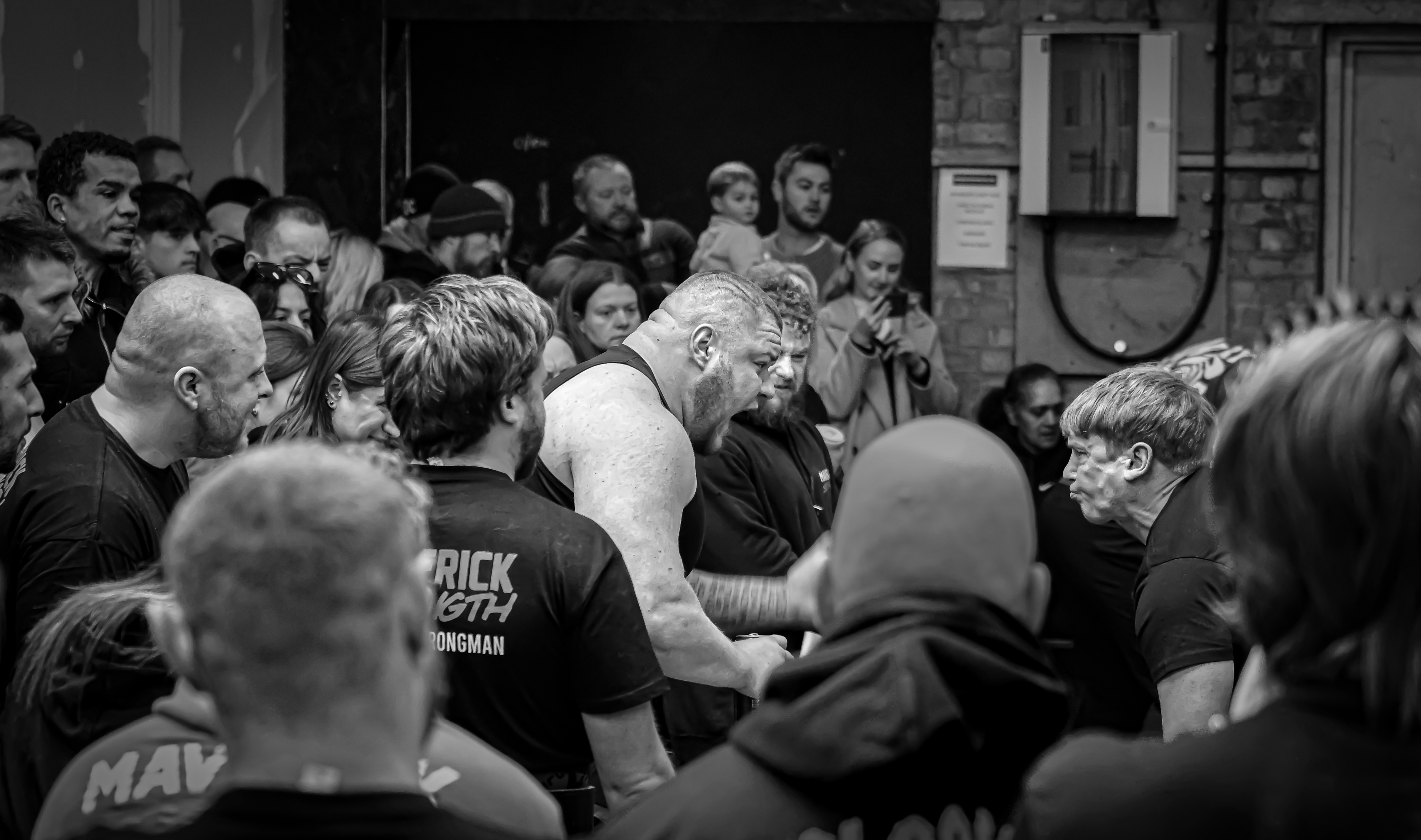 Black and white image of wrestlers with crowd around them