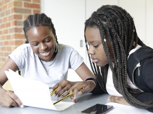 Two young people writing together