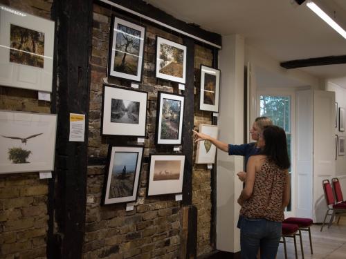 two women looking at photographs in the lower gallery